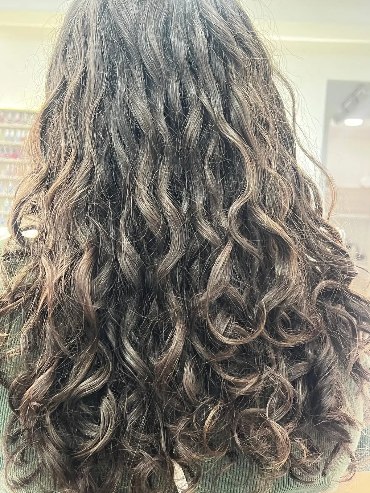 Cabelo castanho cacheado e volumoso visto de costas