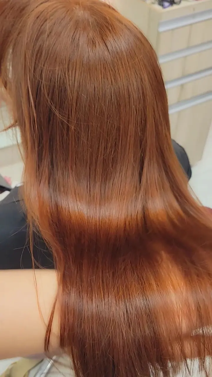 Cabelo ruivo liso e brilhante em movimento, visto de costas